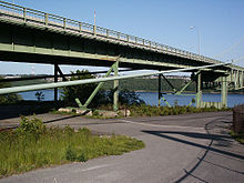 The 450-foot (140 m)-long west approach viaduct. Tower #3 (far right; closest to the suspended structure) extends to the shoreline. Was originally part of Galloping Gertie 1950 TNB west approach viaduct img05.jpg