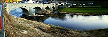 Historische Bogenbrücke bei der Ortschaft Rech über die Ahr mit Bebauung im rechten Vorland. Die Bebauung ist weitgehend im zwanzigsten Jahrhundert in der fluvialen Gewässeraue entstandenen und liegt in den Hochwasserflutwegen, die ursprünglich zum Schutz der Brückenkonstruktion vor einem Volleinstau freigehalten wurden.