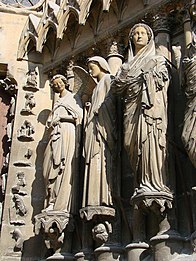 Grupo de la Anunciación del pórtico central de la fachada occidental de la catedral de Reims, con uno de los "ángeles sonrientes" que caracterizan el programa escultórico de todo el edificio. Ca. 1260.