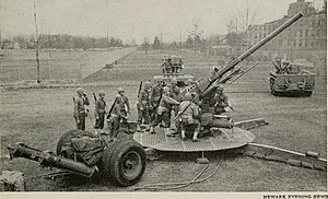 A US 90mm anti-aircraft gun and crew during a demonstration at Bell Laboratories in 1943. The M9 Gun Director can be seen in the center background of the photo.