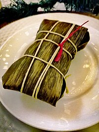 Ayaca is a type of tamal wrapped in banana leaves. The red lint signifies the spiciness level: hot Bonaire Kuminda Krioyo 26.jpg