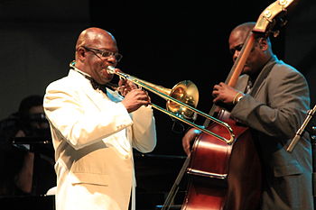 Buena Vista Social Club performing in Lorient in 2012. The image shows trombonist Jesus "Aguaje" Ramos, who replaced Juan de Marcos Gonzalez as the director of the ensemble. He often includes classic descargas such as Generoso Jimenez's "Trombon majadero" in the reperoire of the group. FIL 2012 - Orquesta Buena Vista Social Club 14.JPG