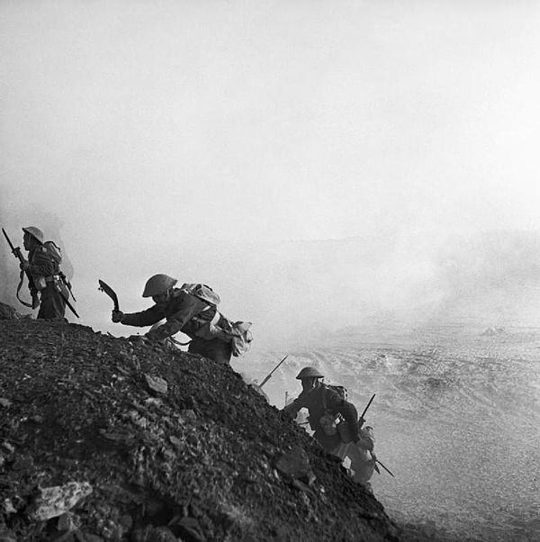 Ghurkhas advance through a smokescreen up a steep slope in Tunisia, 16 March 1943.