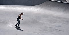 Skatepark with one skateboarder riding