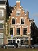 Pand met Haarlemse trapgevel, natuurstenen sierblokken en banden