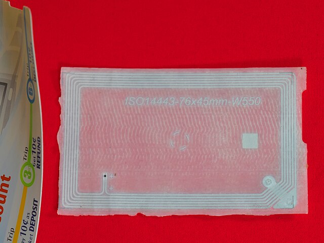 The plastic inlay (right) that contains IC and antenna inside paper contactless smart card used in public transportation in Singapore (left)