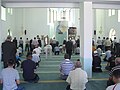 Мужчины сидят и молятся в Республике Косово