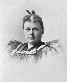 A white woman wearing a ruffled dress, hair in an updo