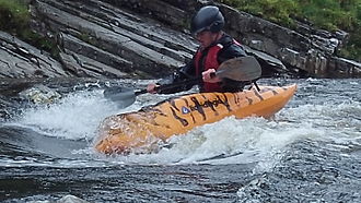 Kayaker surfing on a wave Kayaker surfing on the river Orchy Scotland.jpg