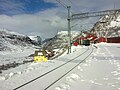 Myrdal stasjon med eit tog på Flåmsbana. Bana går ned dalen til venstre i biletet.