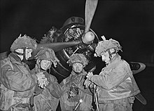 5/6 June 1944. Pathfinder officers synchronising their watches in front of an Armstrong Whitworth Albemarle before flying into battle in Normandy. They all wear 2nd Pattern Denison smocks Operation Tonga.jpg