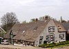 Boerderij onder rieten zadeldak met puntgevel. Rechts uitgebouwde opkamer. In de linker zijgevel van de stal inrijdeuren waarboven een hooiluik met driehoekige houten geveltop