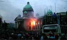 The House of the National Assembly burning during the 2000 Bulldozer Revolution Petooktobarska revolucija.png