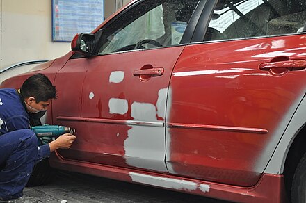 Mechanic repairing a car door