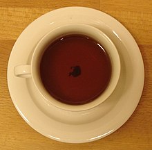The tea leaf paradox is the phenomenon by which tea leaves in a cup of tea migrate to the center and bottom of the cup after being stirred, rather than being forced to the edges as would be expected in a spiral centrifuge. Teacup with Tealeaves on Wooden Table.jpg