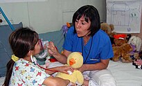 A a child life specialist with Operation Smile US Navy 090706-F-7885G-043 Monica Castaneda, a child life specialist with Operation Smile, introduces a young patient to a stethoscope and breathing mask.jpg