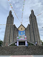 The exterior of the cathedral. It has 3 sections with the main one being sandwiched by the other two. The main section is curved and significantly shorter than the other two towering sections, making the exterior looks like an open Bible in perspective.