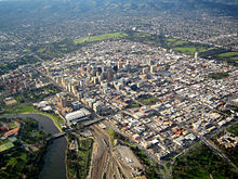 Photographie aérienne en couleurs d'une grande ville avec des immeubles et des zones résidentielles.