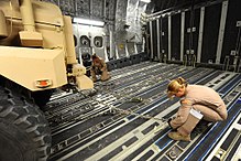 Two USAF loadmasters securing a vehicle inside of an aircraft in 2010 All-female Crew Flies in Honor of Women's History Month DVIDS260087.jpg