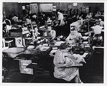 Men and women working in a large office