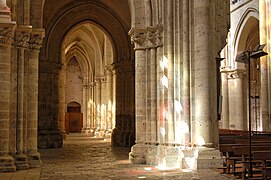 Columnas góticas en sombras y luces coronadas por nervaduras.