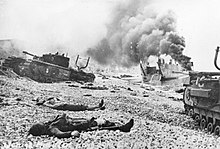 Churchill tanks on the Dieppe beach. The "Y"-shaped pipes on the rear decking are exhaust pipe extensions to allow deep wading. Bodies of Canadian soldiers - Dieppe Raid.jpg