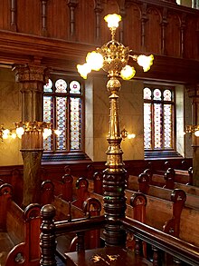 Brass and glass lighting fixtures at pew ends Brass Lighting Fixtures at Pew Ends Eldridge Street Synagogue.jpg