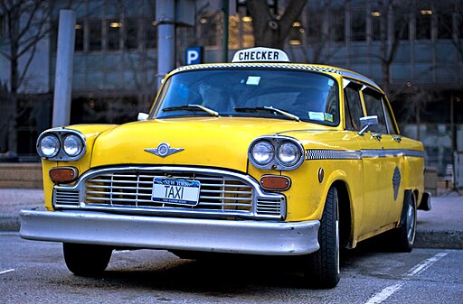 The Checker Taxi Cab, once ubiquitous on NYC Streets, is now a rare sight and hired now mostly for weddings, bar mitzahs, and period movie shoots. (Public domain, via Wikimedia Commons)