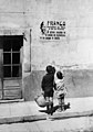 Dos niños haciendo el saludo a la romana frente a un cartel de Franco
