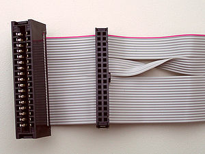 Las almohadillas para conectar unidades de 5¼″ (a la izquierda en la foto) y 3½″ (a la derecha) son diferentes.  Para conectar una unidad de 3½″ a una bahía de unidad de 5¼″ con un cable, se puede usar un adaptador especial.