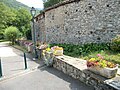 Jardinières fleuri sur un mur le long d'un ruisseau