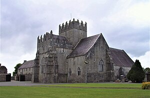 Fotografi av en massiv steinkirke toppet av et tårnetårn.