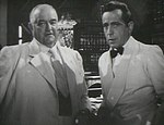 Sydney Greenstreet och Humphrey Bogart i en scen.
