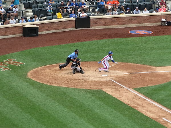 A batter starts his run to reach first base after successfully hitting the ball.