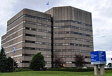 Foto av en grå ti-etasjes bygning bestående av to tilstøtende tårn