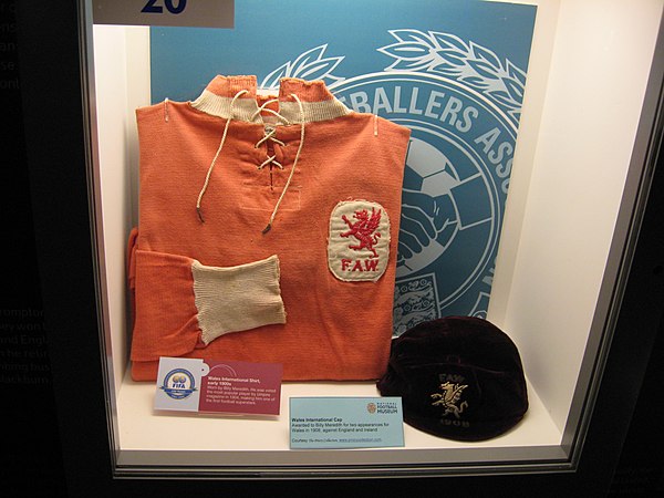 A Wales national team football shirt which was worn by Billy Meredith in the early 1900s, with Welsh cap. On display at the National Football Museum i