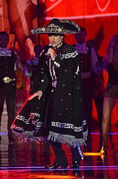 Sängerin im Charro-Outfit singt.