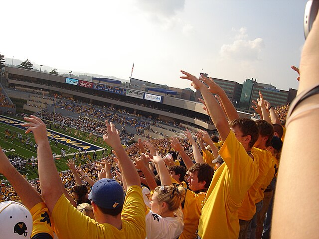 The WVU student section perform the first down cheer at a home football game.