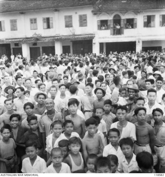 Crowds throng a street in Kuching to witness the arrival of Australian Imperial Force (AIF) on 12 September 1945.