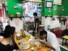 Bulkhead barrier in a restaurant in Hanoi. Beginning from 19 August 2020, bars and restaurants which do not follow epidemic prevention protocols will be fined and forced to close. Newone - tam chan COVID.jpg