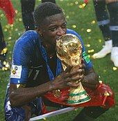 The current trophy (held by France forward Ousmane Dembele in 2018) has been presented since 1974 Ousmane Dembele World Cup Trophy.jpg