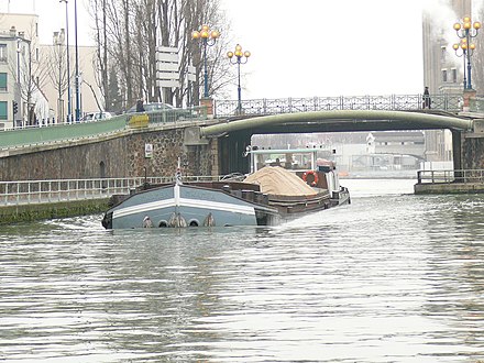 Un automoteur de canal au pont de la Mairie de Pantin. Il est chargé à près de 350 tonnes.