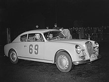 Louis Chiron et Ciro Basadonna vainqueurs du rallye Monte-Carlo 1954 sur la Lancia Aurélia B24 GT 2500 spider n°69 (ici, lors du passage de ralliement par Amsterdam).