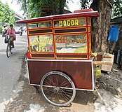 A travelling Soto mie bogor cart on Jakarta street, with the ingredients displayed on the window