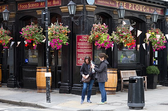 Couple of tourists searching for directions on map in London, UK.