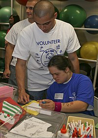 U.S. Marine Corps Sgt. Bolivar Ruano, left, an engine mechanic with Marine Aviation Logistics Squadron (MALS) 29, does arts and crafts with an athlete competing in the 2011 Special Olympics Onslow County Fall 111202-M-JO751-176