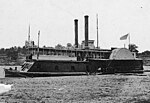 Black and white photo shows a riverboat with the number 13 and two smokestacks. The lower deck has a sloping casemate with gunports.