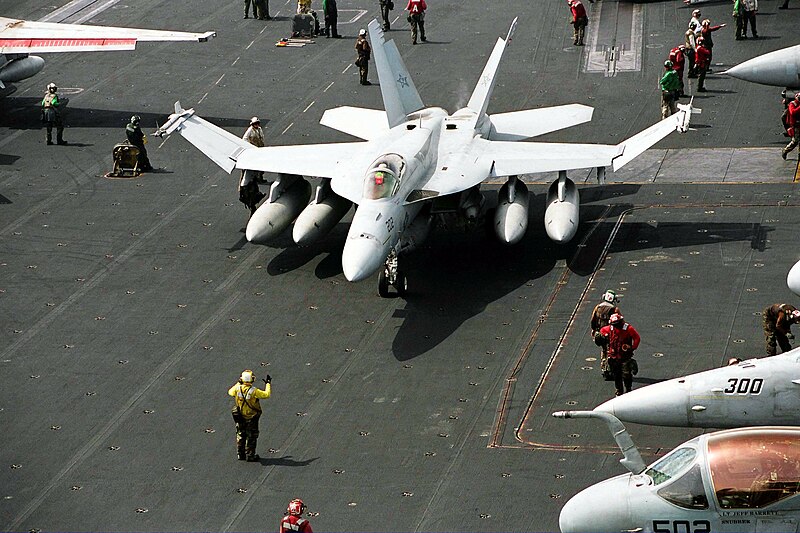 File:US Navy 030404-N-9951B-004 An Aviation Boatswain's Mate directs an F-A-18E Super Hornet assigned to the "Tophatters" of Strike Fighter Squadron Fourteen (VFA-14) into position for launch from the flight deck a.jpg