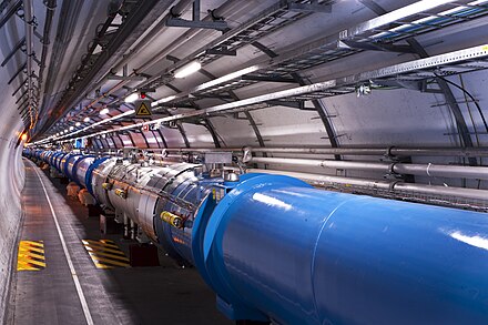 A section of the LHC tunnel. The dipole magnets are painted in a blue colour, to protect them from rust.[103]