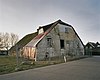 Boerderij, waarvan woon- en bedrijfsgedeelte onder een rieten zadeldak. Gepleisterde voorgevel met sierankers, vensters met luiken en zesruitsschuiframen en links een opkamer, waaronder getoogd keldervenster. In de stal inrijdeuren onder opgewipt gedeelte